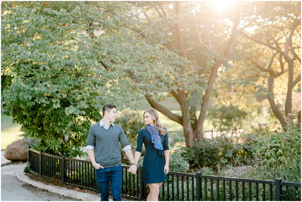 couple walking in the Chicago Lincoln Park during  golden hour engagement session
