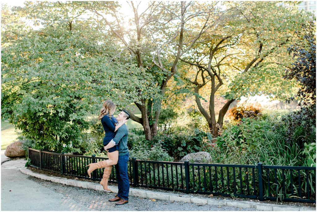 sunset engagement session in Chicago Lincoln park zoo, guy is lifting girl, they are looking at each other with love
