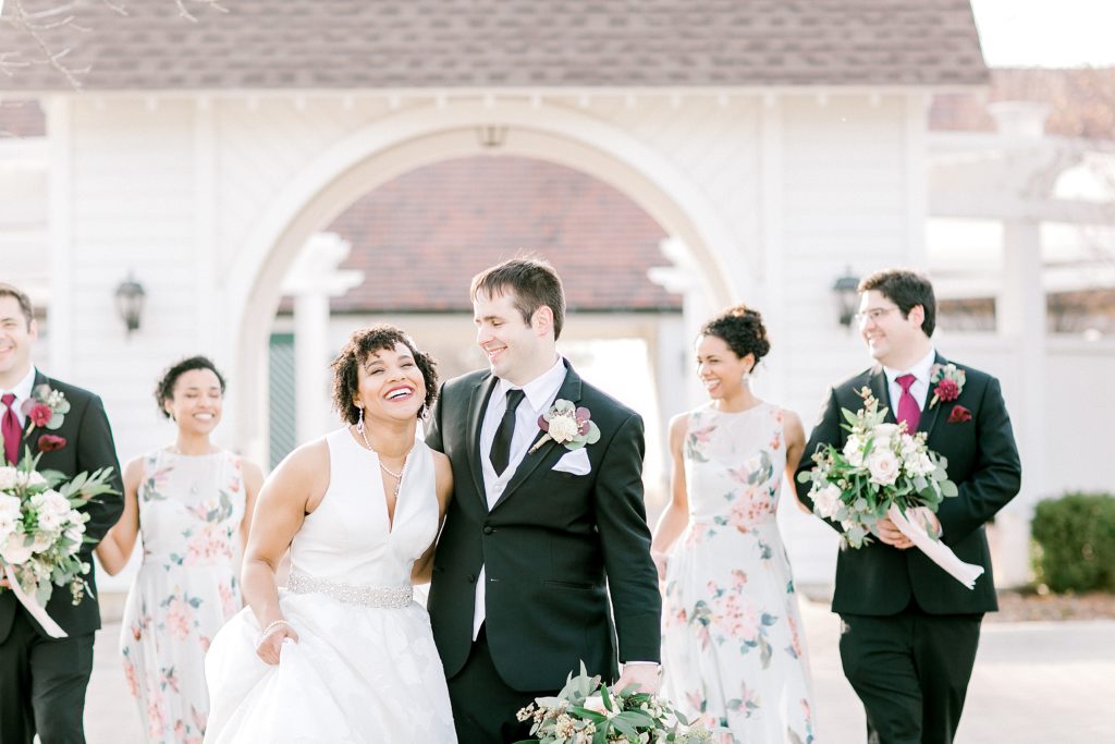 bridal party walking and laughing in front of danada house in Naperville IL 