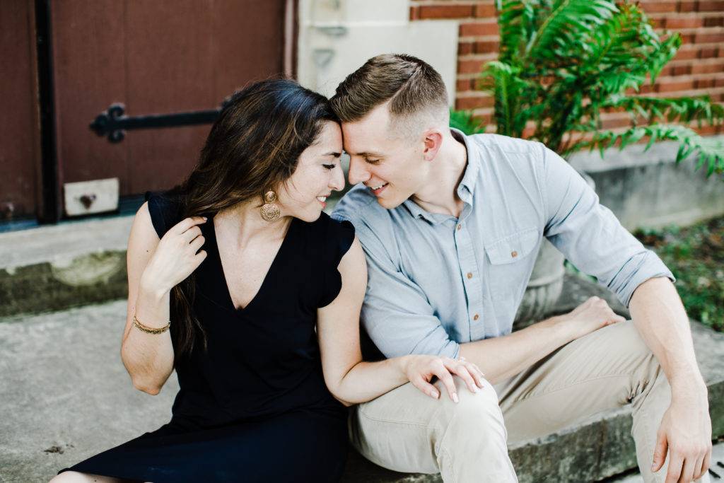 engagement session couple sitting on the stairs and touching their foreheads
