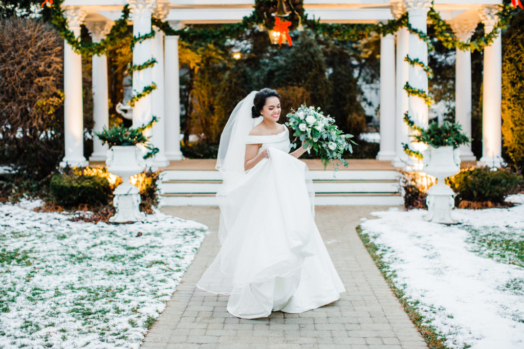  bride dancing outside in snowy surroundings behind her white gazebo