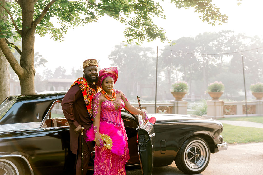 In their Nigerian-inspired fuchsia attire, the couple's engagement session with a vintage car becomes a celebration of diversity, love, and the beauty of merging cultures.