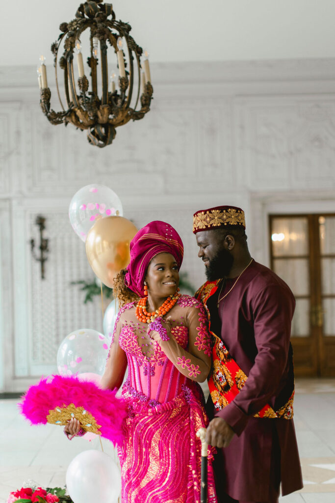 The vibrant fuchsia-colored outfits, intricately crafted with Nigerian national custom, beautifully reflect the couple's heritage and love story.