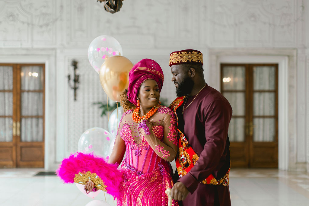 With their striking fuchsia outfits, the couple creates a visual spectacle, capturing the essence of their love story intertwined with the vibrancy of Nigerian customs against the backdrop of Armour House.