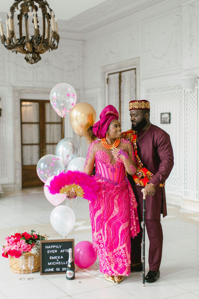 The couple's Nigerian custom-made fuchsia outfits create a stunning contrast against the timeless backdrop of the engagement session symbolizing the merging of traditions and love.