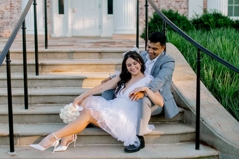 Couple sitting together on the steps of Cantigny Park’s mansion, sharing a playful glance.