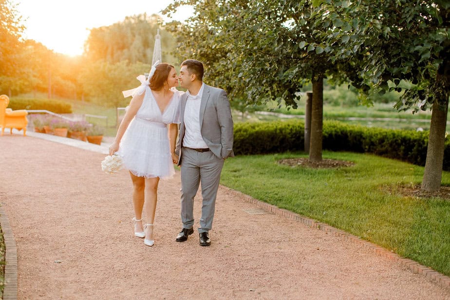 Couple holding hands while walking across a beautifully landscaped lawn at Cantigny Park.