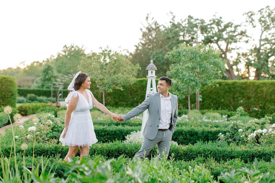 Joyful moment of the couple laughing while surrounded by vibrant garden blooms at Cantigny Park.