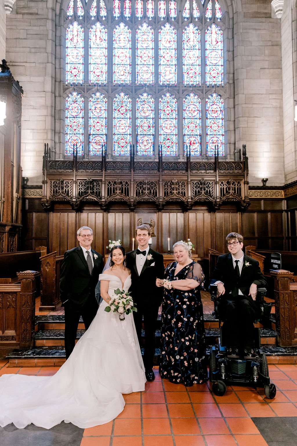 Bride and groom with bride’s full family, standing in a church”